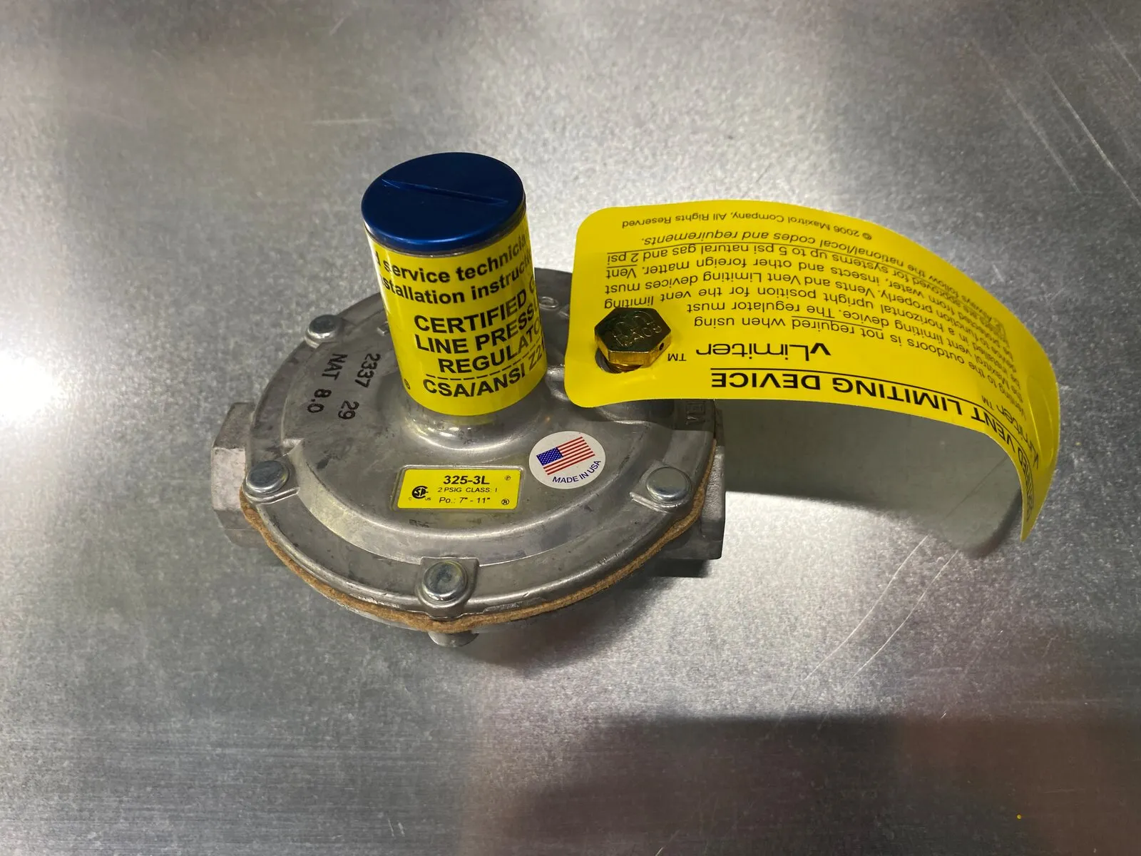 Régulateur de pression de ligne de gaz avec son limiteur d’évent et son étiquette d’instructions jaune