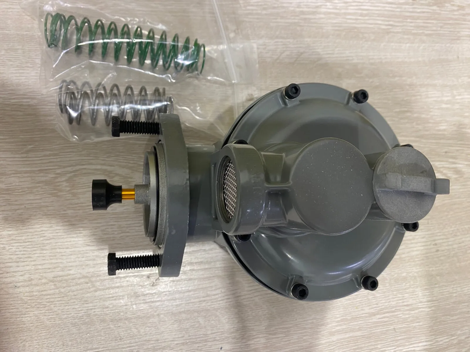 Régulateur de pression de gaz ouvert, à côté de sa trousse de ressorts de rechange et de son orifice