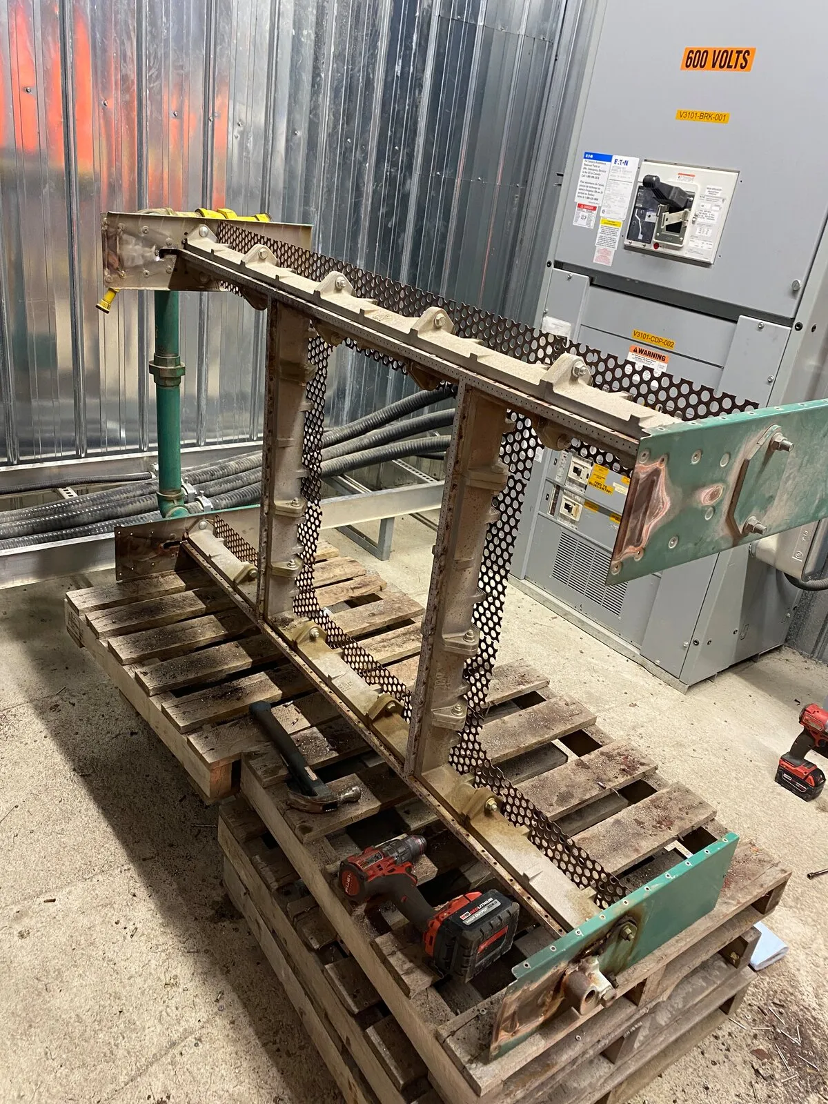 Châssis de brûleur d’un appareil de chauffage sur mesure sur des palettes avec des outils, en cours de remise à neuf sur site