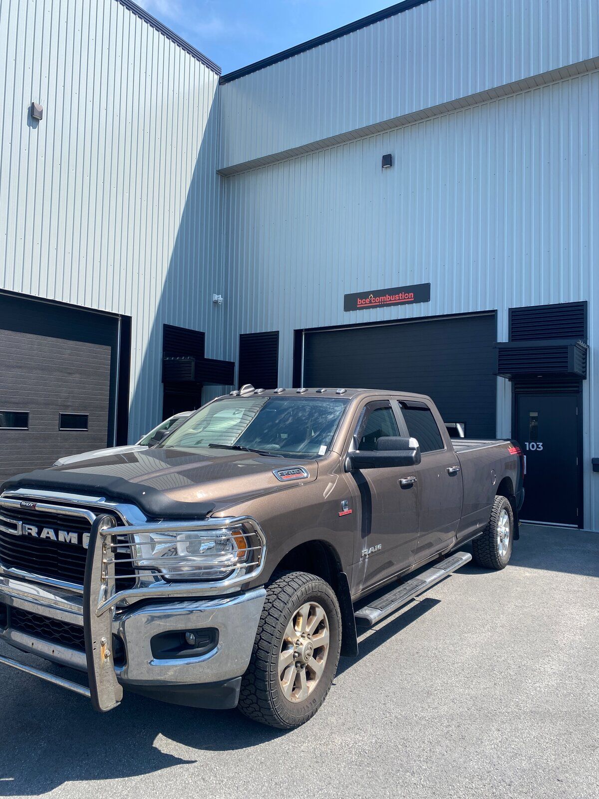L’atelier de BCE Combustion à Gatineau — un bâtiment d’acier blanc avec l’enseigne BCE Combustion au-dessus de la porte de garage et un camion de service stationné devant